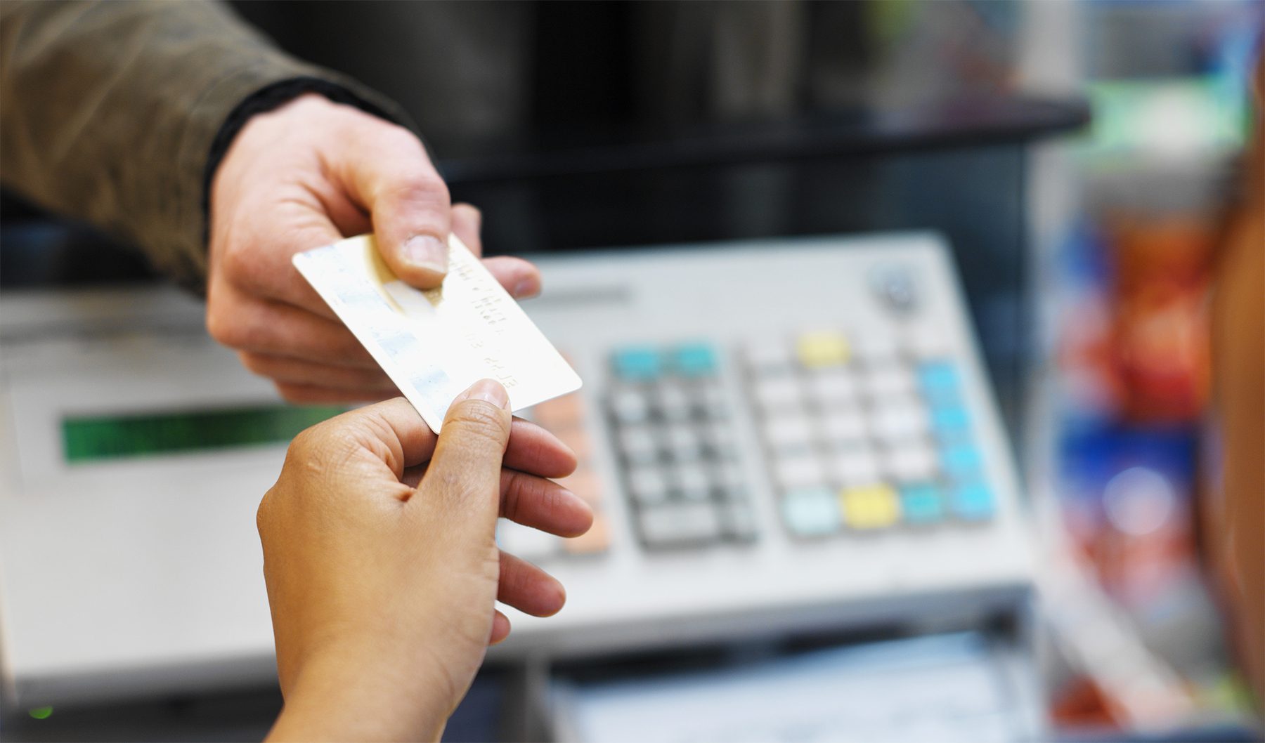 Patient handing credit card to clinic receptionist for payment at front desk.