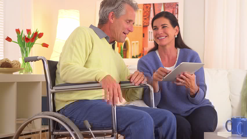 Healthcare professional using tablet to review patient information with client.