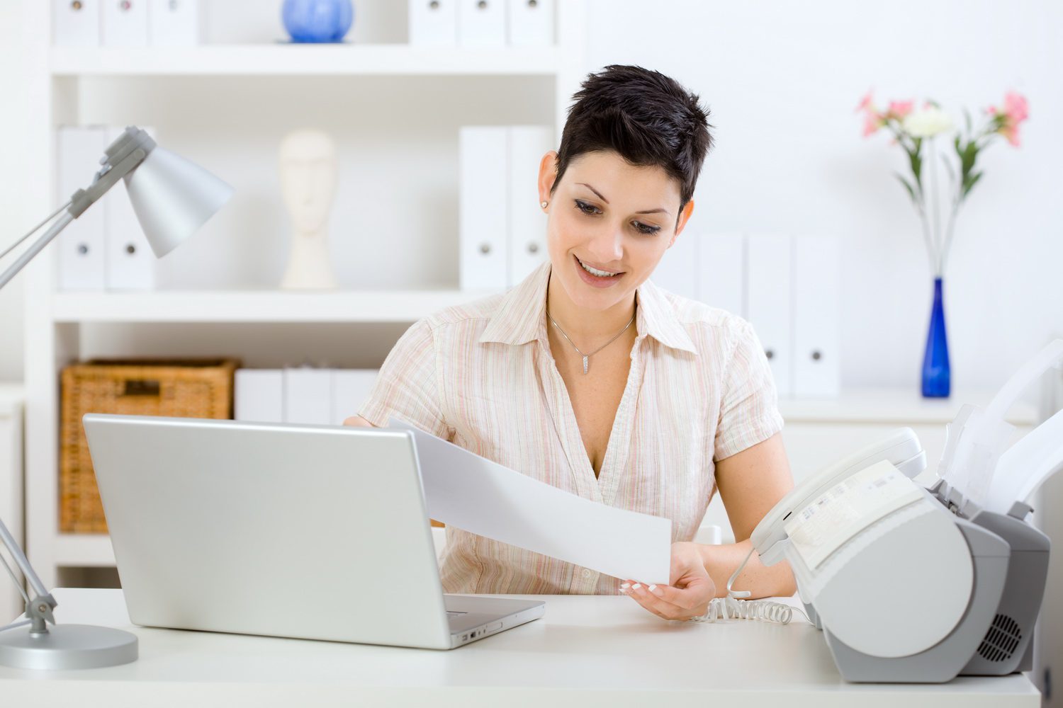 Office worker sending documents through integrated fax system on computer.