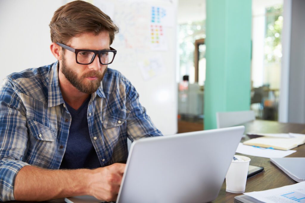 Professional attending virtual training session on computer at workplace.
