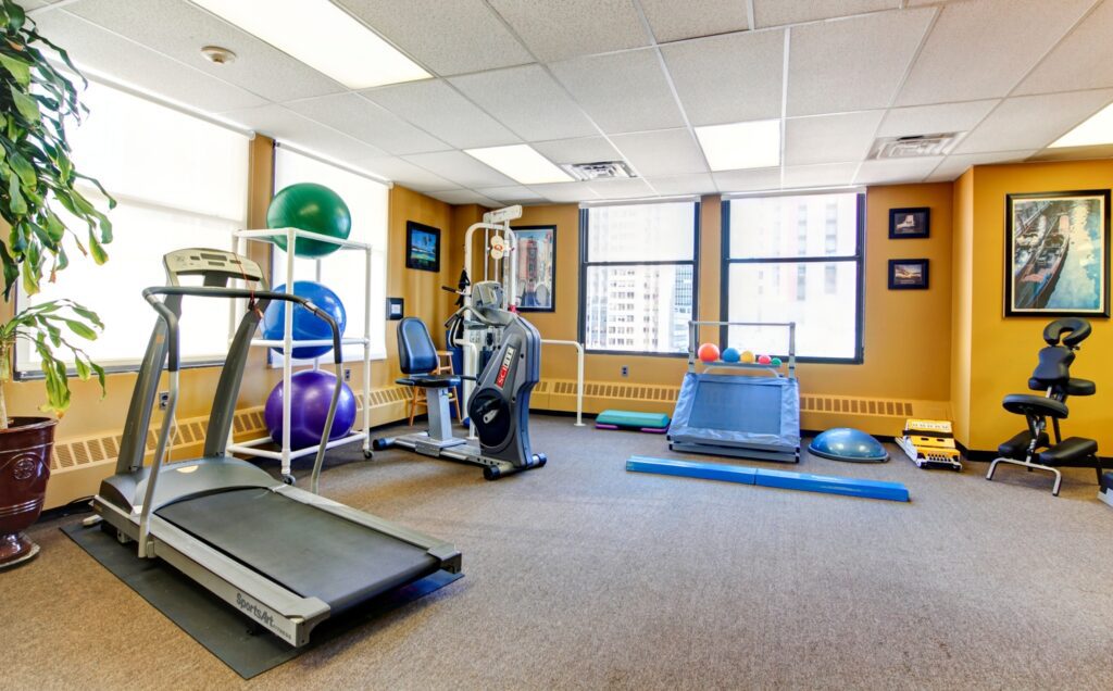 Modern physical therapy clinic with exercise equipment and rehabilitation tools.