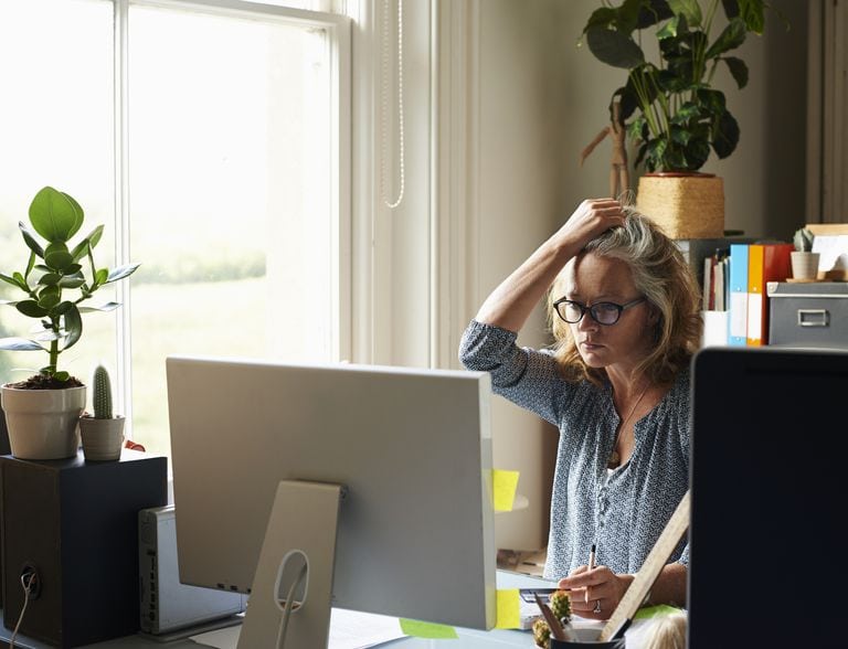 Frustrated woman at computer managing appointment reminders.
