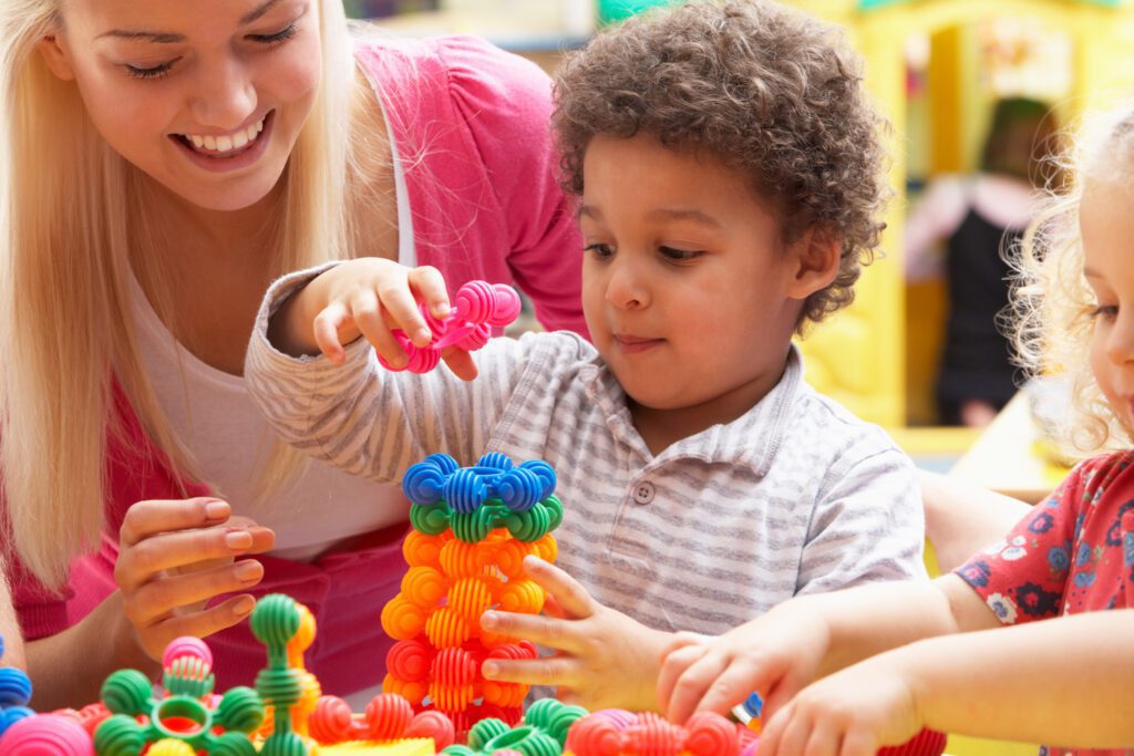 Child playing with colourful sensory toys during occupational therapy session.