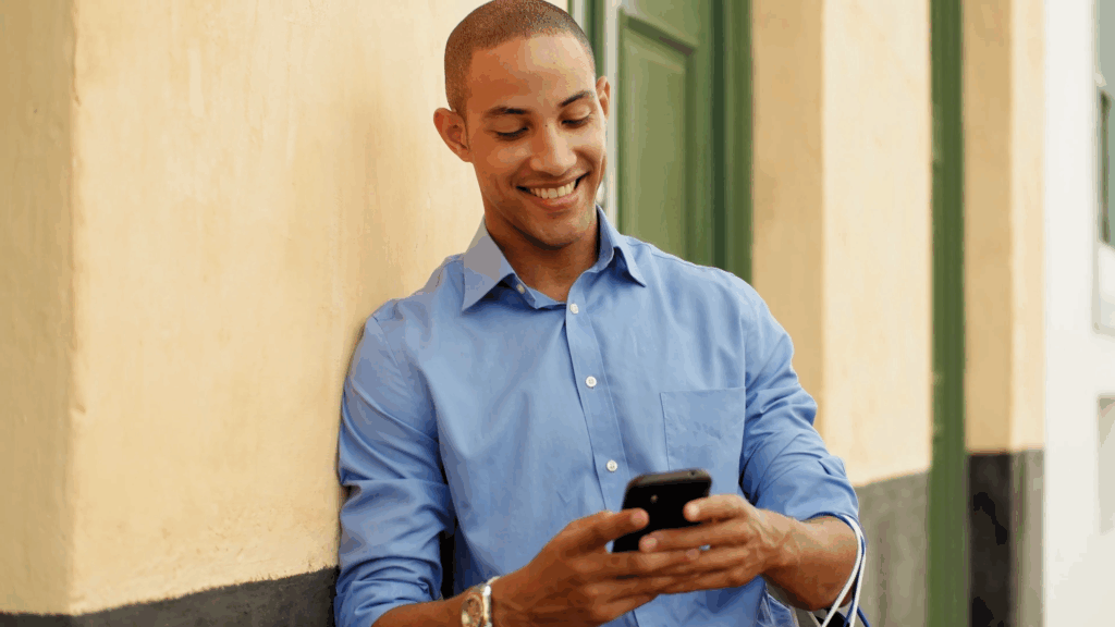 Smiling man reading messages on his smartphone, representing positive feedback about Wired Client.