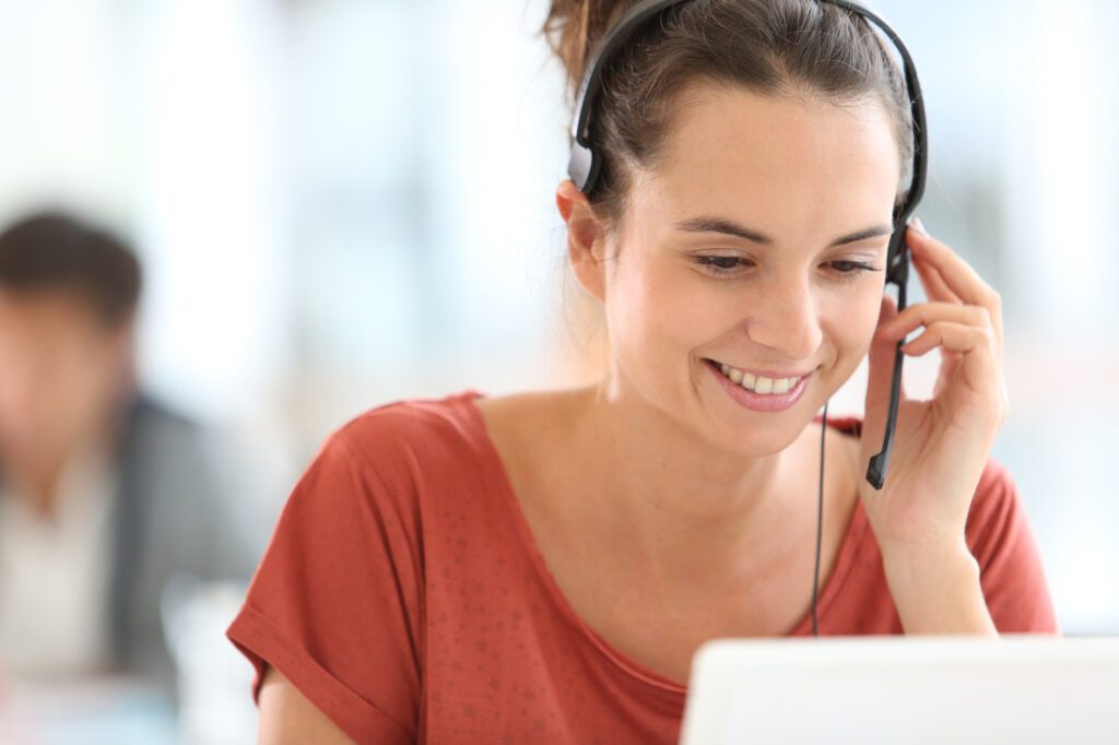 Woman with headset providing IT support, representing secure cloud backup and data safety practices.