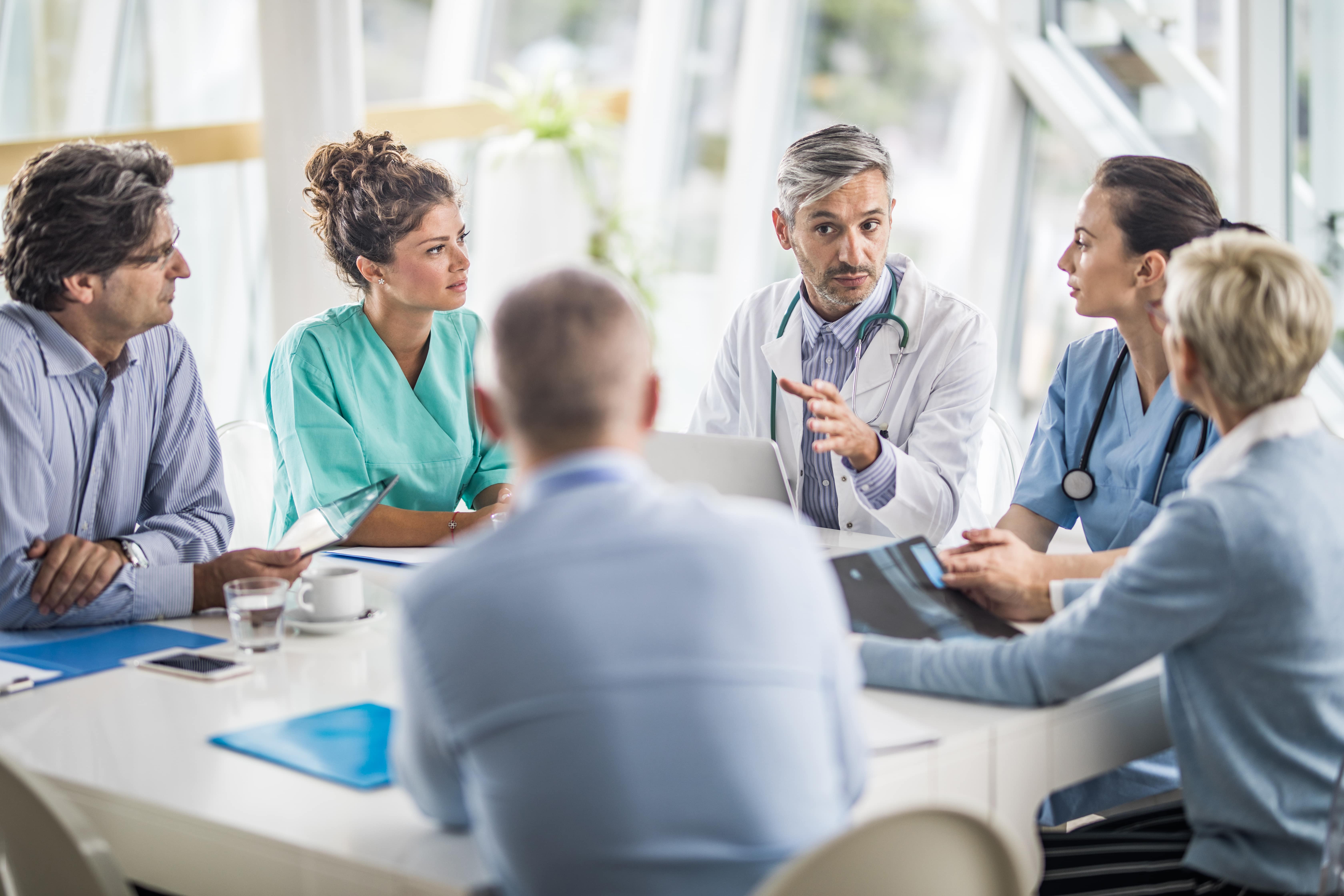 Physicians sitting around table at meeting