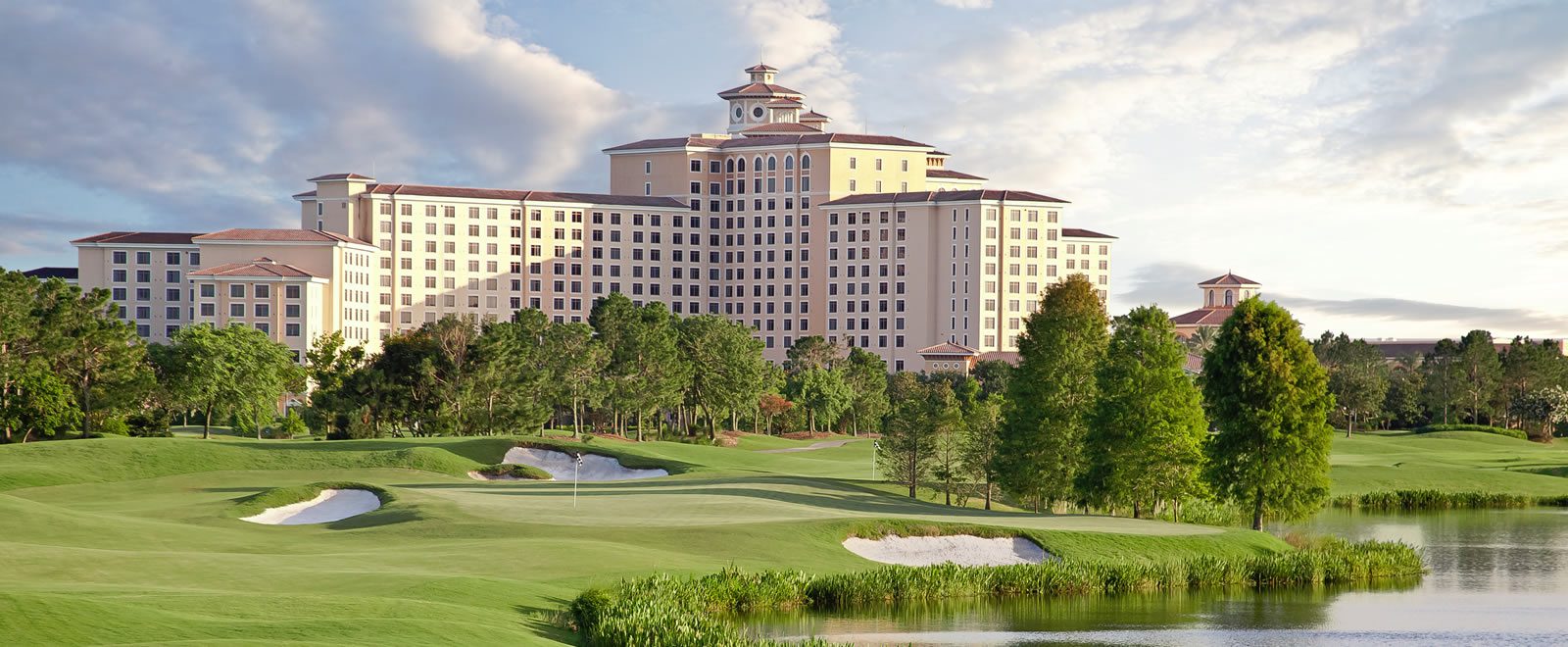 Exterior view of the Rosen Shingle Creek hotel where the PPS 2019 Conference took place surrounded by greenery and water at sunrise.
