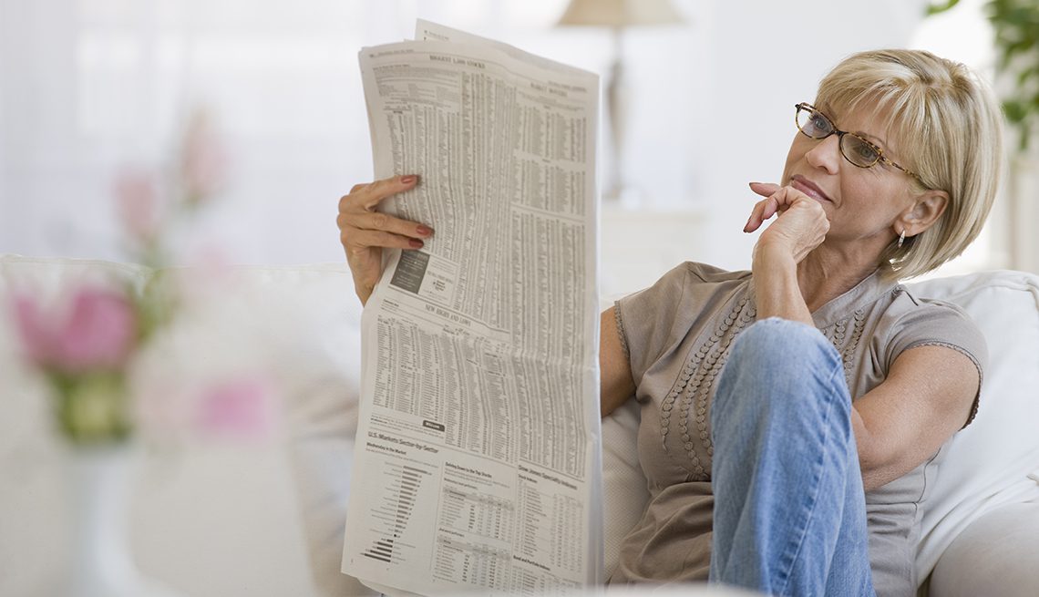 Woman reading printed newspaper at home, symbolizing Practice Perfect’s healthcare newsletter.