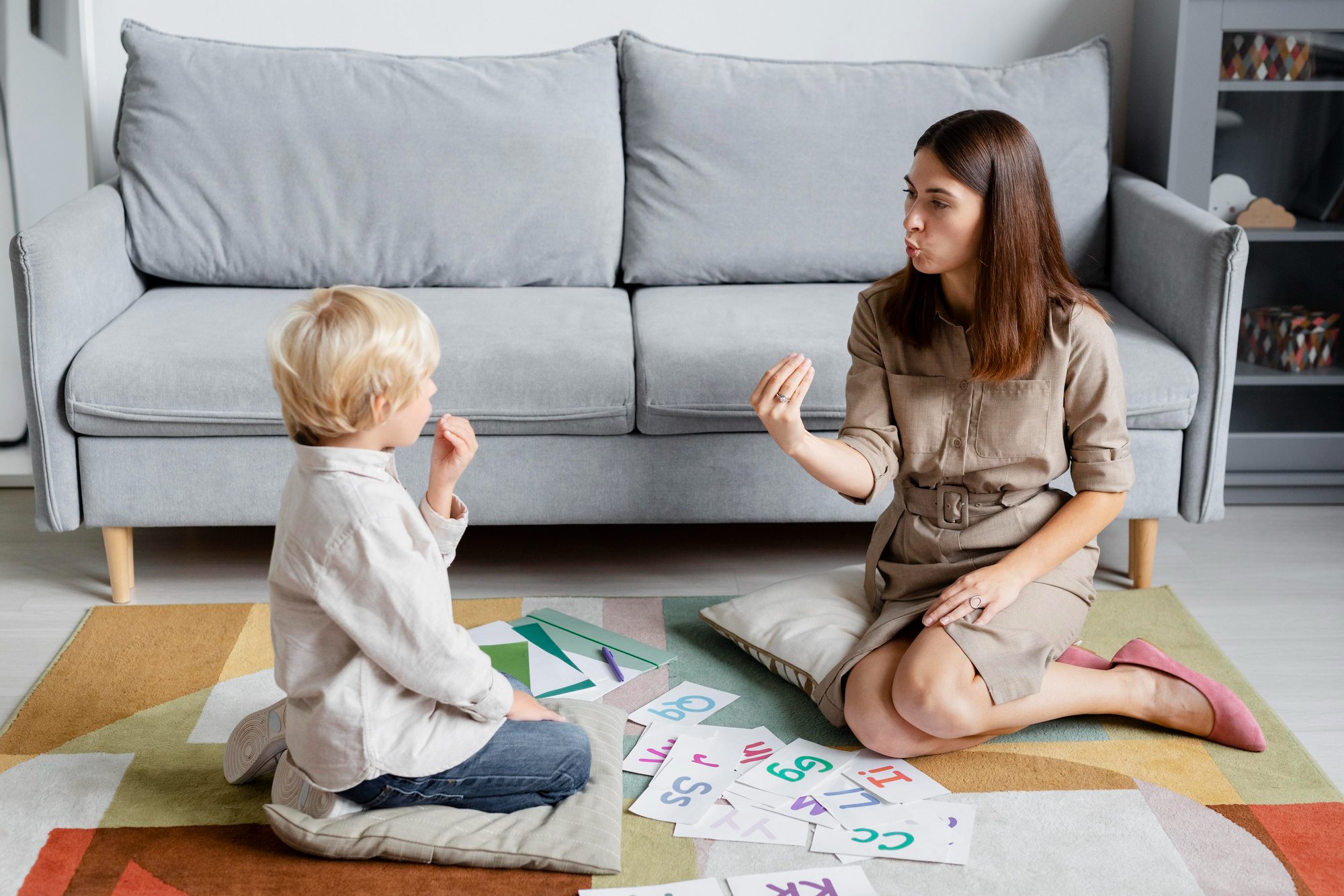 Speech therapist teaching pronunciation exercises to a young boy during a therapy session.