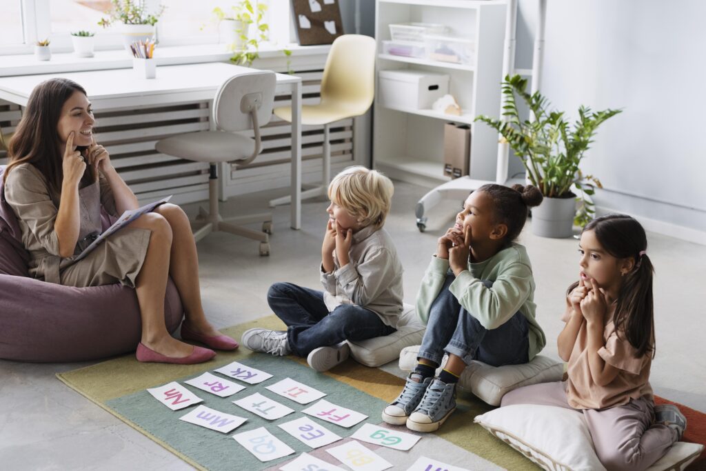 Speech therapist leading a pronunciation exercise with children in a classroom setting.