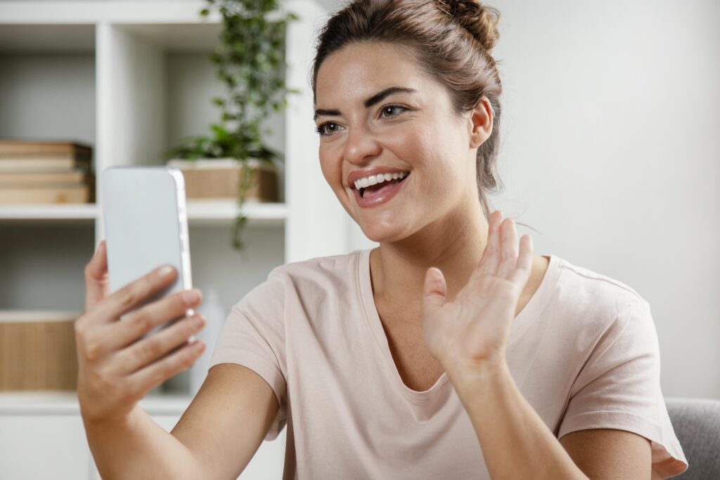 Happy woman participating in an online telehealth consultation through smartphone.