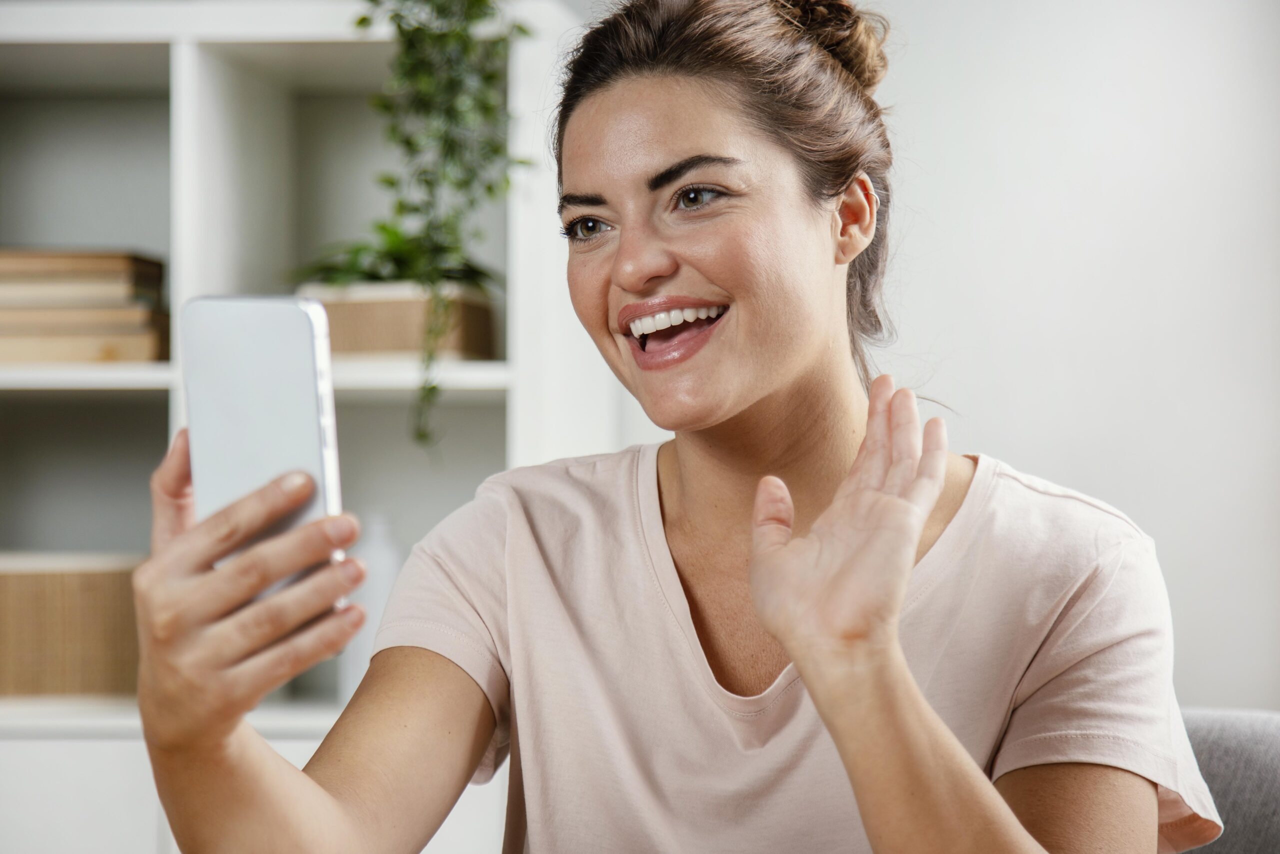 Happy woman participating in an online telehealth consultation through smartphone.