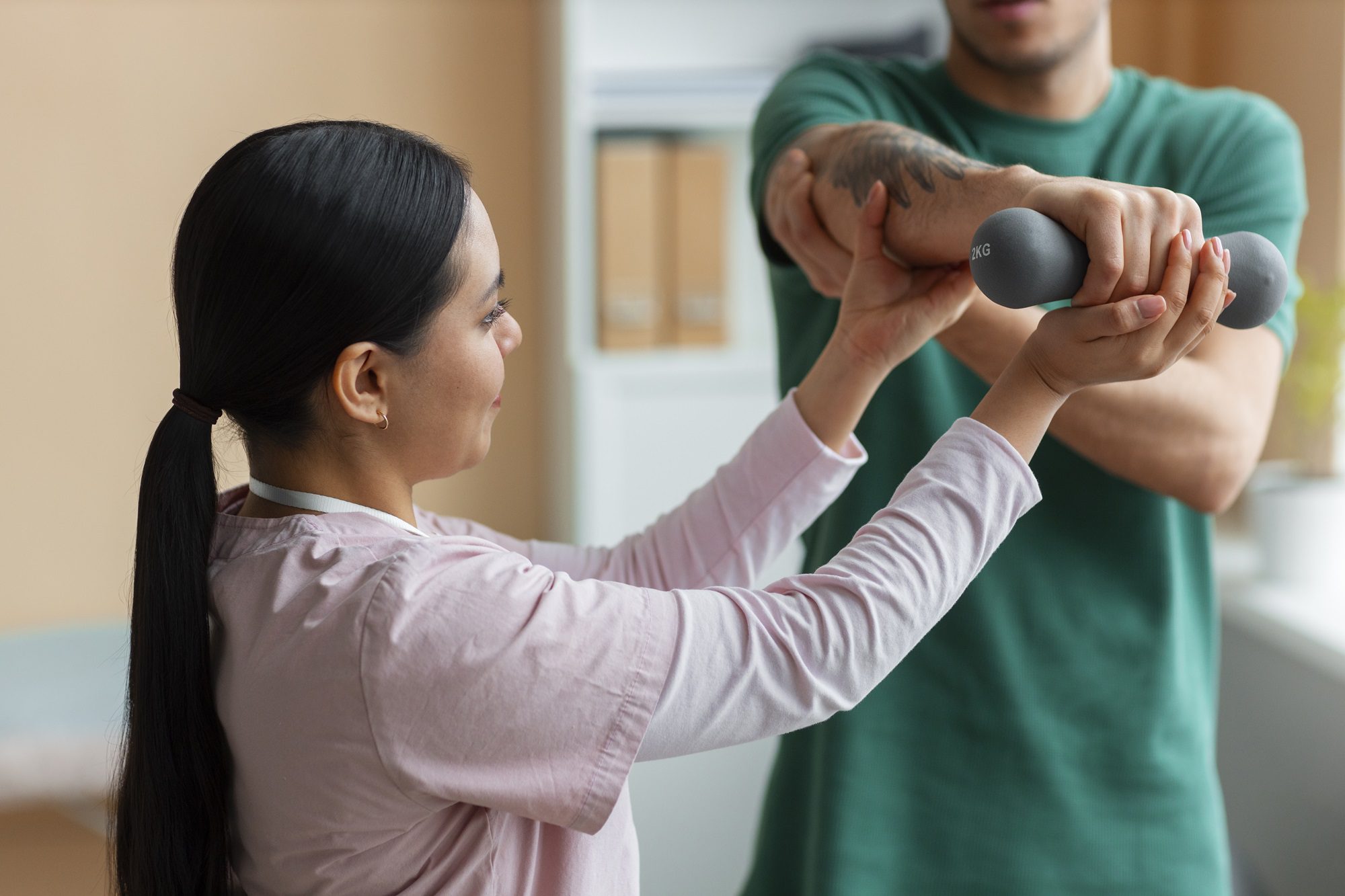 Therapist guiding patient through upper limb rehabilitation workout with light weight.